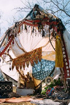 there is a canopy covered in fabric and other things on the ground next to it