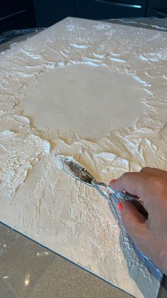 a person is spreading dough with a spatula