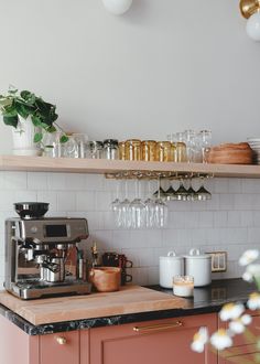 the kitchen counter is full of cups and glasses on top of the shelves, along with pots and pans