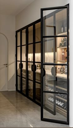 an empty kitchen with glass doors leading to the wine cellar