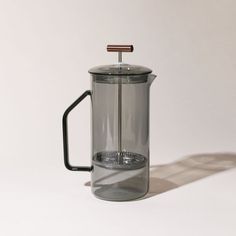 a glass french press coffee maker with a wooden handle