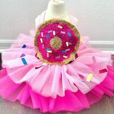 a dress made out of pink tulle with sprinkles and a donut on it