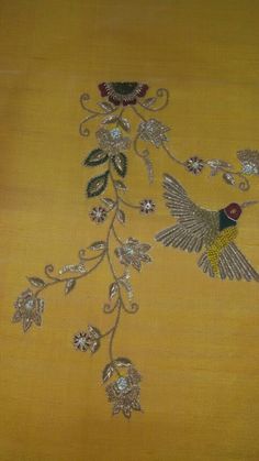 an embroidered yellow cloth with birds and flowers on the side, along with other decorative items