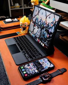 an open laptop computer sitting on top of a desk next to a phone and other electronics