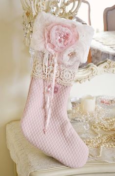 a pink christmas stocking hanging from a chandelier