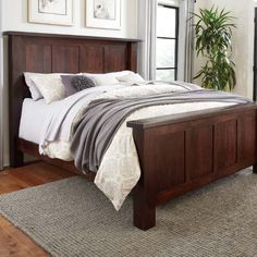 a bed sitting in a bedroom on top of a wooden floor next to a window