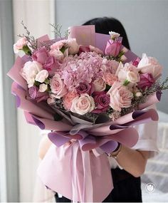 a woman holding a large bouquet of flowers