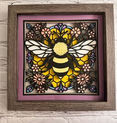 a stained glass window with a bee on it's side and flowers in the middle