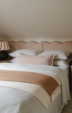 a bed with two lamps on either side of the headboard and an end table next to it