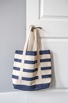 Perfect for everyday adventure. Versatile and functional, this hand-embroidered Kantha stitch tote adds a level of character and texture to the classic Americana stripe design. Carefully constructed with a durable duck cotton canvas lining, interior, and exterior slip pockets to help better organize your most used items. From everyday errands to farmer's markets, this bag is with you through all of life’s adventures. #anchalproject #fairtrade #artisanmade #ethicaldesign #sustainablefashion Striped Tote Bag, Classic Americana, Navy Stripes, Navy Color, Canvas Tote Bag, Ethical Fashion, Stripes Design