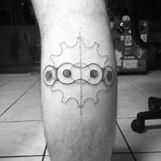 a man's leg with a tattoo on it that has gears in the middle