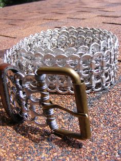 a pair of metal bracelets sitting on top of a sidewalk