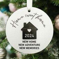 a personalized ornament hanging on a christmas tree for someone's new home