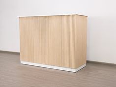 a wooden box sitting on top of a hard wood floor next to a white wall