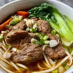 a white bowl filled with meat and noodles