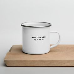 a white enamel mug sitting on top of a wooden board with the words wildbee inside