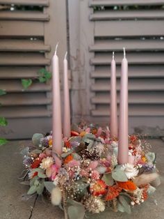 a bunch of candles that are sitting in some kind of bowl with flowers on it