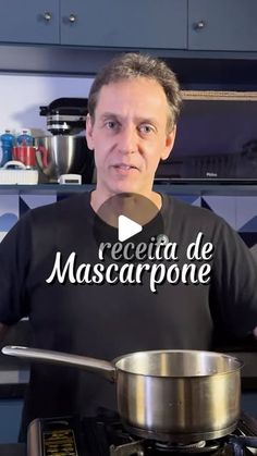 a man in a black shirt is holding a spoon over a pan on the stove