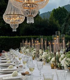 the table is set with white flowers and crystal chandelier hanging from the ceiling