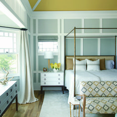 a bedroom with a four poster bed and white furniture