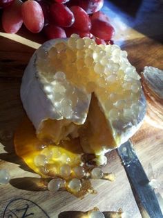 grapes and cheese on a cutting board next to a knife