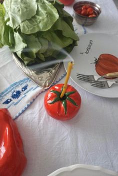 tomatoes, lettuce and other vegetables are on the table with utensils