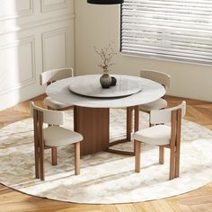 a round table with four chairs and a vase on it in the middle of a room