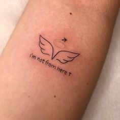 a small tattoo with the words i'm not from here and an angel on it