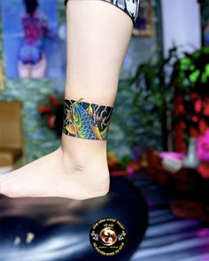 a woman's foot with a tattoo on it and a flower in the background