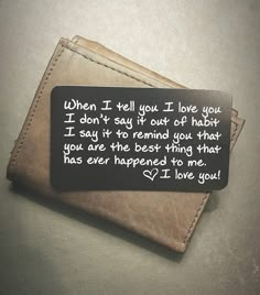 a wallet with a poem written on it sitting on top of a table next to a cell phone