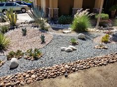 a car parked in front of a house next to a gravel driveway and landscaping area