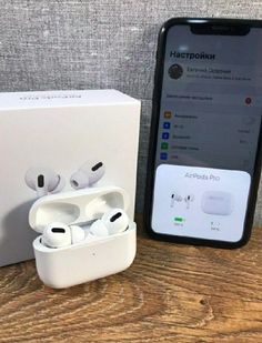 an iphone and earphones sitting next to each other on a wooden table in front of a box