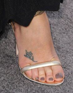 a close up of a person's foot with a tattoo on her left ankle