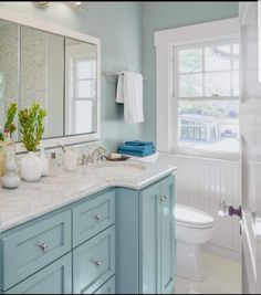 a bathroom with blue cabinets and white fixtures