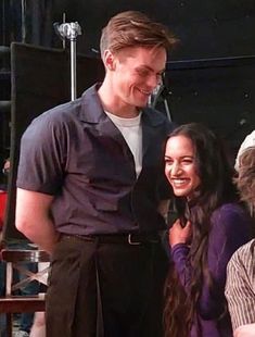 two people standing next to each other smiling