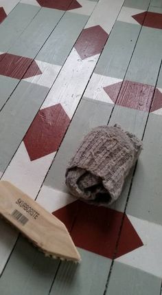 a wooden object laying on the floor next to it's brush and paper towel