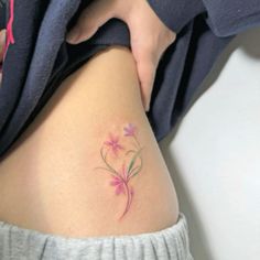 a woman's thigh with a flower tattoo on her lower leg and the bottom part of her stomach