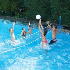 people playing volleyball in a swimming pool