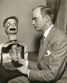 an old photo of a man with a dummy in front of him and another statue behind him