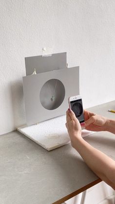 a person sitting at a table with a cell phone in front of a projector