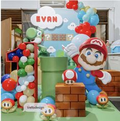 a nintendo themed birthday party with balloons, mario and balloon decorations on the table in front of it