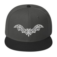 Goth style whimsical Halloween Flying Bat. Symbolism used in Goth, Gothic and Horror Subculture. Associated with Dracula and Nosferatu. This is the snapback of your dreams! It's structured and high-profile, with a flat visor and a subtle grey under visor. * 85% acrylic, 15% wool * Structured, 6-panel, high-profile * Plastic snap closure * Grey under visor * Head circumference: 22″-24″ (55-60 cm) This product is made especially for you as soon as you place an order, which is why it takes us a bit Bat Symbolism, Goth Hats, Goth Hat, Goth Cottagecore, Flying Bat, White Gothic, Fairycore Grunge, Embroidered Flats, Whimsical Halloween