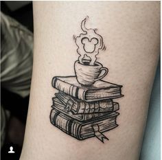 a stack of books with a steaming cup on top