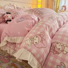 a pink and white bed with hello kitty comforters