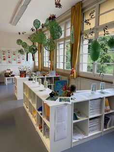 an empty room with many bookshelves and plants in the window sills