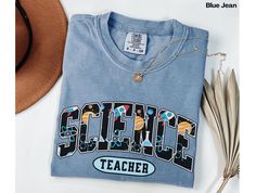 a t - shirt with the word science on it next to feathers and a hat