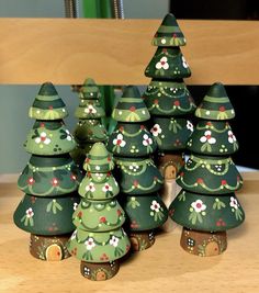 a group of green christmas trees sitting on top of a wooden table