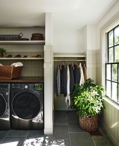 a washer and dryer in a laundry room next to a window with open shelving