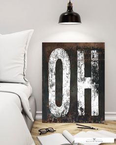 an old metal sign with the word oh on it sitting next to a book and eyeglasses