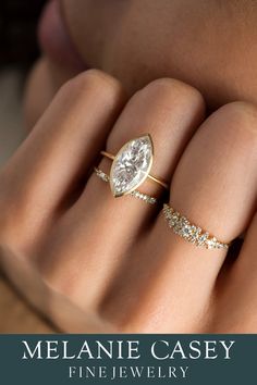 a woman's hand with two rings on her fingers and the words melanie casey fine jewelry